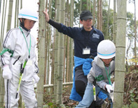 竹を切る小学生と見守る野口健氏写真