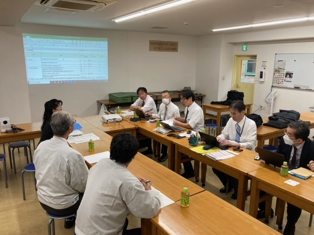 お取引先様の会議室で当社監査員が実地監査を行っている様子